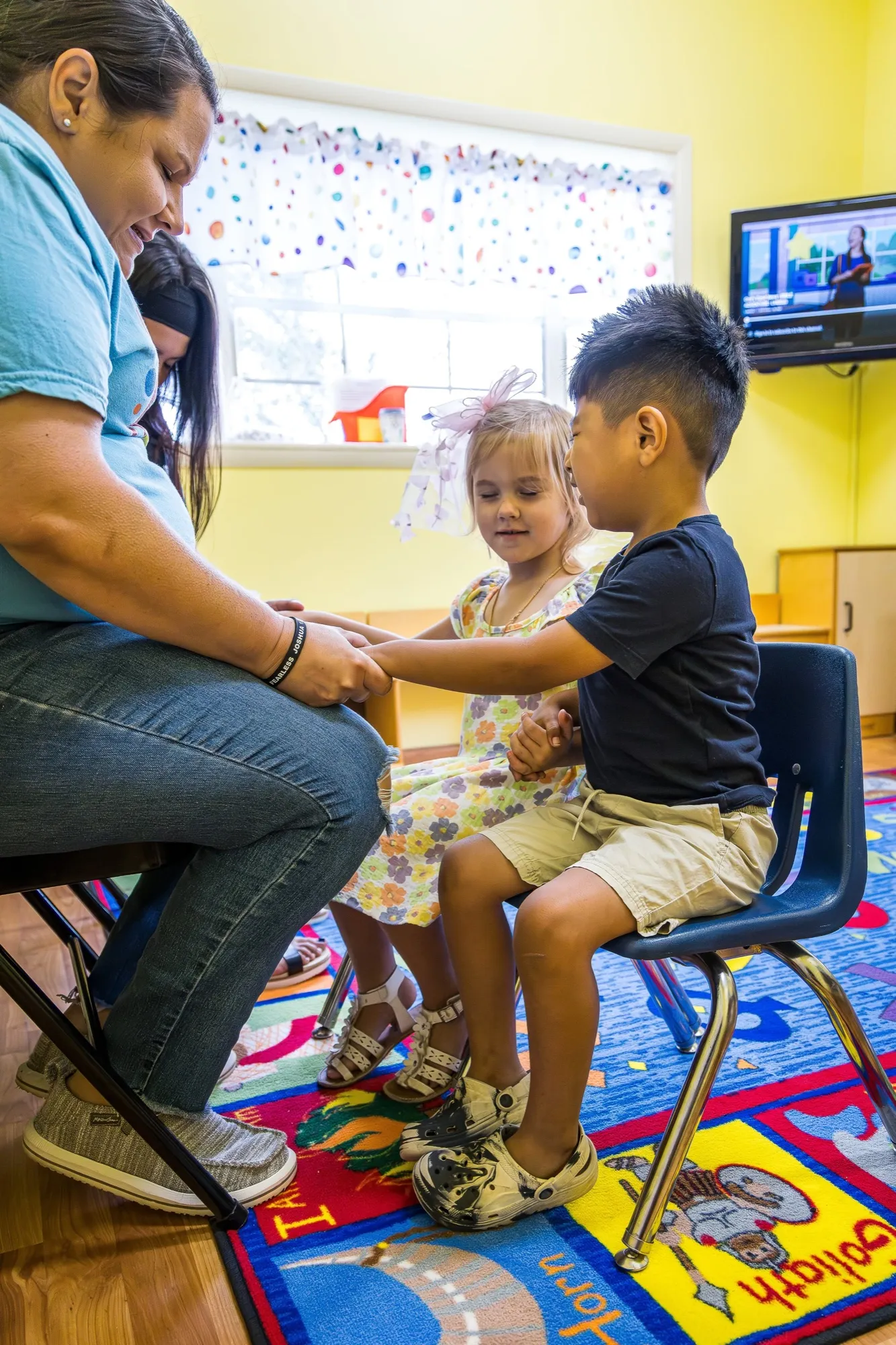 A Crossing Kids leader praying with two children