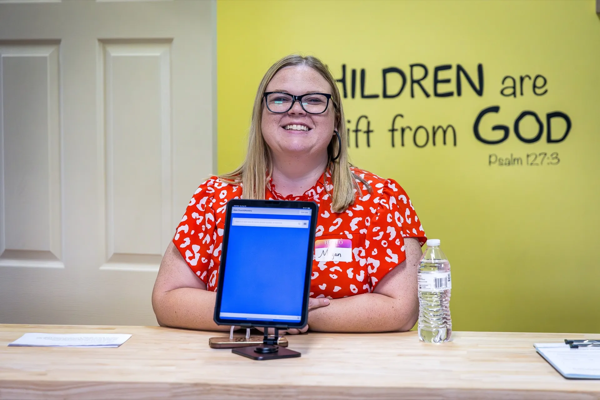 A Crossing Kids team member welcoming families at the check-in desk