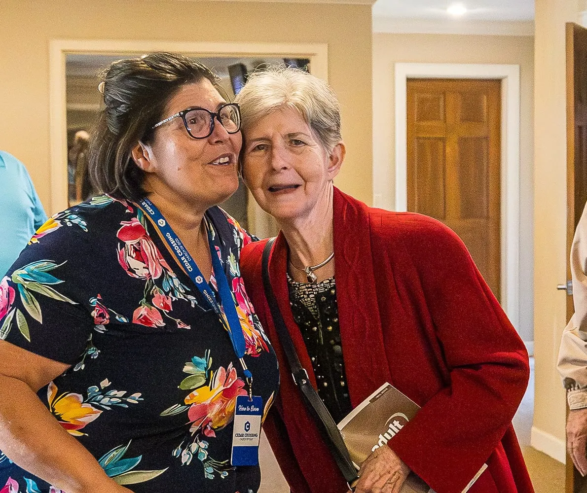 Two women sharing a joyful moment at Cedar Crossing