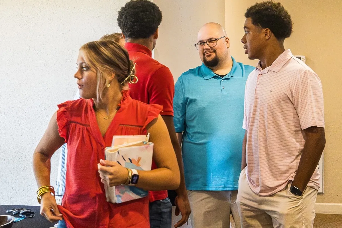 Adults and students fellowshipping before service